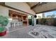 Covered patio with sliding doors opening to a modern kitchen and a cozy outdoor seating area at 6832 Apogee Ridge Ct, Las Vegas, NV 89135