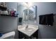 Compact bathroom featuring a white corner sink, mirror, and a shelf for toiletries at 7485 Rainbow Spray Dr, Las Vegas, NV 89131