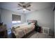 A serene bedroom featuring a wood-framed bed, a ceiling fan, and a window with a gray roller shade at 7485 Rainbow Spray Dr, Las Vegas, NV 89131