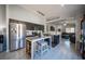 Open kitchen layout with stainless steel refrigerator, island, and view into the living room at 7485 Rainbow Spray Dr, Las Vegas, NV 89131