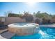 Inviting backyard pool featuring a unique stone hot tub with cascading waterfall at 7485 Rainbow Spray Dr, Las Vegas, NV 89131