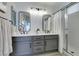 Bathroom featuring double sinks with large mirrors and walk-in shower at 7608 Little Valley Ave, Las Vegas, NV 89147