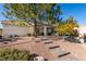 Desert landscaped yard with walkway leading to the front door and mature shade trees at 7608 Little Valley Ave, Las Vegas, NV 89147