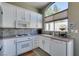 Bright kitchen featuring white cabinets, updated appliances, and decorative backsplash at 7608 Little Valley Ave, Las Vegas, NV 89147