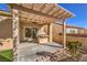 Backyard with covered patio includes a built-in barbecue and low-maintenance landscape at 7928 Broadwing Dr, North Las Vegas, NV 89084