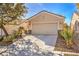 Front exterior view of this home features an attached two car garage and desert landscaping at 7928 Broadwing Dr, North Las Vegas, NV 89084