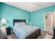 Bright bedroom featuring a ceiling fan, aqua walls, and neutral carpet at 8106 Buffalo Clan Ct, Las Vegas, NV 89131