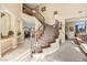 Spacious foyer features curved staircase, tile flooring and access to formal living areas at 8106 Buffalo Clan Ct, Las Vegas, NV 89131