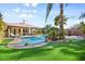 Home's backyard with in-ground pool, turf, and beautiful landscaping at 8145 Mountain Forest Ct, Las Vegas, NV 89129