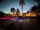 Inviting backyard pool and spa illuminated at dusk, surrounded by lush palm trees and lounge seating at 8145 Mountain Forest Ct, Las Vegas, NV 89129