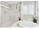 Bright bathroom featuring a glass shower stall, soaking tub, and decorative wall art at 8145 Mountain Forest Ct, Las Vegas, NV 89129