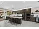 Modern kitchen featuring dark cabinets, stainless steel appliances, and a large center island with bar seating at 8145 Mountain Forest Ct, Las Vegas, NV 89129