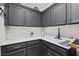 Laundry room featuring grey cabinets, white countertop, and matte black faucet at 8145 Mountain Forest Ct, Las Vegas, NV 89129