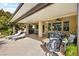 Large covered patio with lounge chairs and dining area overlooking manicured backyard at 8145 Mountain Forest Ct, Las Vegas, NV 89129