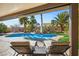 Lounge chairs overlook a pool with palm trees and a rock waterfall feature at 8145 Mountain Forest Ct, Las Vegas, NV 89129