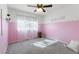 Pink bedroom with carpet, light streaming through the sheer curtains, and a ceiling fan at 8212 Ducharme Ave, Las Vegas, NV 89145