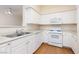 Well-lit kitchen featuring white cabinetry, modern appliances, and wood-look flooring at 9000 Las Vegas Blvd # 1245, Las Vegas, NV 89123