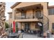 Exterior view of the home showing the outdoor dining area, grill, spiral staircase, and upper-level balcony at 9012 Alpine Peaks Ave, Las Vegas, NV 89147