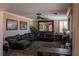 The inviting living room features a large leather couch, a ceiling fan, carpet, and neutral paint at 9012 Alpine Peaks Ave, Las Vegas, NV 89147