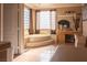 This main bathroom features a soaking tub with large windows and dual vanities at 9012 Alpine Peaks Ave, Las Vegas, NV 89147