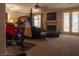 This main bedroom features a fireplace, a sitting area, french doors, and a peloton exercise bike at 9012 Alpine Peaks Ave, Las Vegas, NV 89147