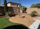 Inviting backyard with a charming fire pit, artificial grass, and well-maintained landscaping at 9364 Olympia Falls Ave, Las Vegas, NV 89149