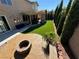 Beautiful backyard space featuring a stone fire pit, artificial grass, and covered patio seating at 9364 Olympia Falls Ave, Las Vegas, NV 89149