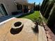 Gorgeous backyard featuring a stone fire pit, artificial grass, and covered patio space at 9364 Olympia Falls Ave, Las Vegas, NV 89149