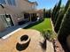 Relaxing backyard with a stone fire pit, artificial grass, and covered patio at 9364 Olympia Falls Ave, Las Vegas, NV 89149