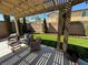 Comfortable backyard patio area with pergola, outdoor seating, and a well-manicured lawn at 9364 Olympia Falls Ave, Las Vegas, NV 89149