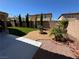 Relaxing backyard retreat with a stone fire pit, artificial turf, and mature trees at 9364 Olympia Falls Ave, Las Vegas, NV 89149