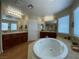 Large bathroom features a soaking tub, tile flooring, and double sink vanities at 9364 Olympia Falls Ave, Las Vegas, NV 89149