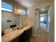 Bathroom vanity and mirror with hall access and natural light at 9364 Olympia Falls Ave, Las Vegas, NV 89149