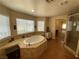 Bathroom features a soaking tub, tiled floors, a walk-in shower, and a double vanity at 9364 Olympia Falls Ave, Las Vegas, NV 89149