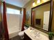 Neutral bathroom with a shower-tub combination and a decorative mirror above the sink at 9364 Olympia Falls Ave, Las Vegas, NV 89149