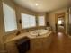 Bathroom features a soaking tub and ample counter space with views to the hallway at 9364 Olympia Falls Ave, Las Vegas, NV 89149