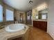 Bathroom features a soaking tub, tiled floors, a walk-in shower, and a double vanity sink at 9364 Olympia Falls Ave, Las Vegas, NV 89149