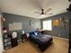 Cozy bedroom with a ceiling fan and natural light streaming through a bright window at 9364 Olympia Falls Ave, Las Vegas, NV 89149