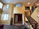 Bright and airy foyer showcasing an elegant staircase with iron railings and a view of the home's entrance at 9364 Olympia Falls Ave, Las Vegas, NV 89149