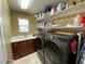 Functional laundry room with modern washer and dryer, sink, countertop, and storage shelves at 9364 Olympia Falls Ave, Las Vegas, NV 89149