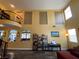 Spacious living room featuring soaring ceilings, large windows, and decorative wrought iron balcony at 9364 Olympia Falls Ave, Las Vegas, NV 89149