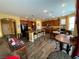 A casual living space connecting the living room, kitchen, and dining area with warm walls and hardwood floors at 9364 Olympia Falls Ave, Las Vegas, NV 89149