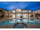 Backyard view of large swimming pool, covered patio, and landscaped yard at dusk at 9795 La Cienega St, Las Vegas, NV 89183