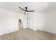 Bedroom with a ceiling fan, closet, wood floors, and view to the staircase at 9795 La Cienega St, Las Vegas, NV 89183