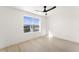 Minimalist bedroom with a ceiling fan and a large window offering natural light at 9795 La Cienega St, Las Vegas, NV 89183