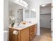 Primary bathroom featuring double sinks, oak cabinets, large mirrors and a walk in closet at 10651 Streamside Ave, Las Vegas, NV 89129