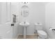 Well-lit bathroom features a pedestal sink, an oval mirror, and a white toilet with tiled floors at 10651 Streamside Ave, Las Vegas, NV 89129