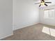 Bright and cozy bedroom with neutral carpet, ceiling fan, and a window letting in natural light at 10651 Streamside Ave, Las Vegas, NV 89129