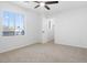 Bedroom featuring neutral carpeting, a ceiling fan, and a view through a large window at 10651 Streamside Ave, Las Vegas, NV 89129