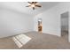 Carpeted room with ceiling fan, natural light and a view of a bathroom and hallway at 10651 Streamside Ave, Las Vegas, NV 89129